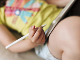 child writing on an iPad with apple pen